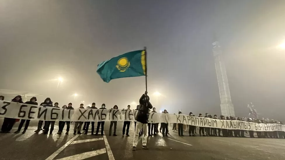Протестующие в Алматы держали транспарант с надписью «Мы не террористы» незадолго до стрельбы 6 января.